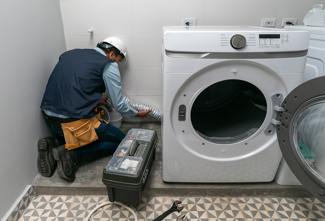 Latin American repairman installing a washing machine at a house